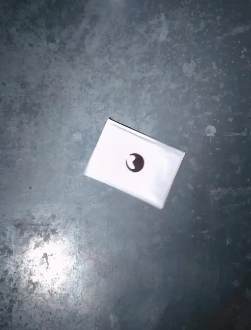 Enveloppe blanche marquée du sceau Maison Jurko, posée sur une table en béton